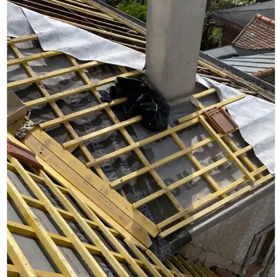 Souche de cheminée et écran de sous-toiture au pied du conduit pendant des travaux de couverture MCT